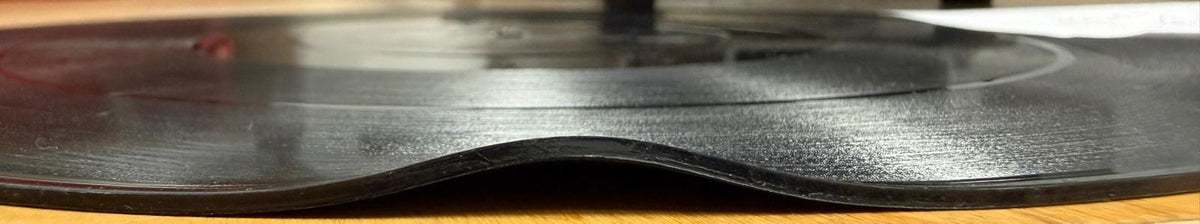Warp 1 Close-up of a vinyl record with a a sharp bend at the edge